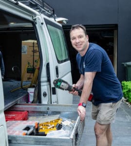 Pascoe Vale plumber confidently holding a plumbing tool beside his fully-equipped van in Victoria.