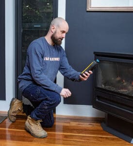 A Malvern plumber kneels down to conduct a CO2 test, detecting the carbon dioxide levels of the heater in Victoria resident.