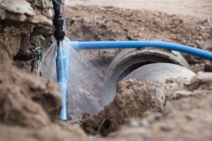 Water pipe break .Exposing a burst water main, focused on the spraying water and the pipe.