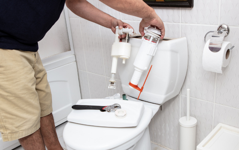 plumber performing toilet repairs